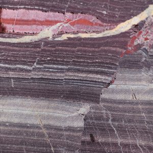 Rock sample from the Barberton core showing a closeup of orange and dark red striations