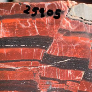 Closeup of rock specimen with dark red and brown layers