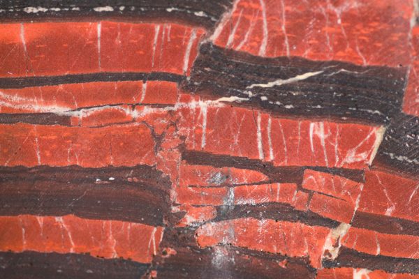 Rock sample from the Barberton core showing a closeup of orange and dark red striations