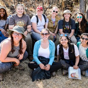 Group shot of 10 smiling female students posing outdoors in South Africa.