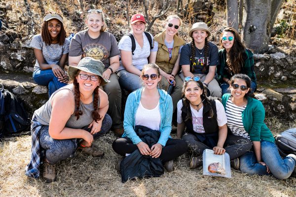 Group shot of 10 smiling female students posing outdoors in South Africa.
