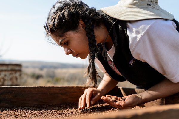 UW-Madison student Talia Sankari uses a sifting screen to sort for potential artifacts